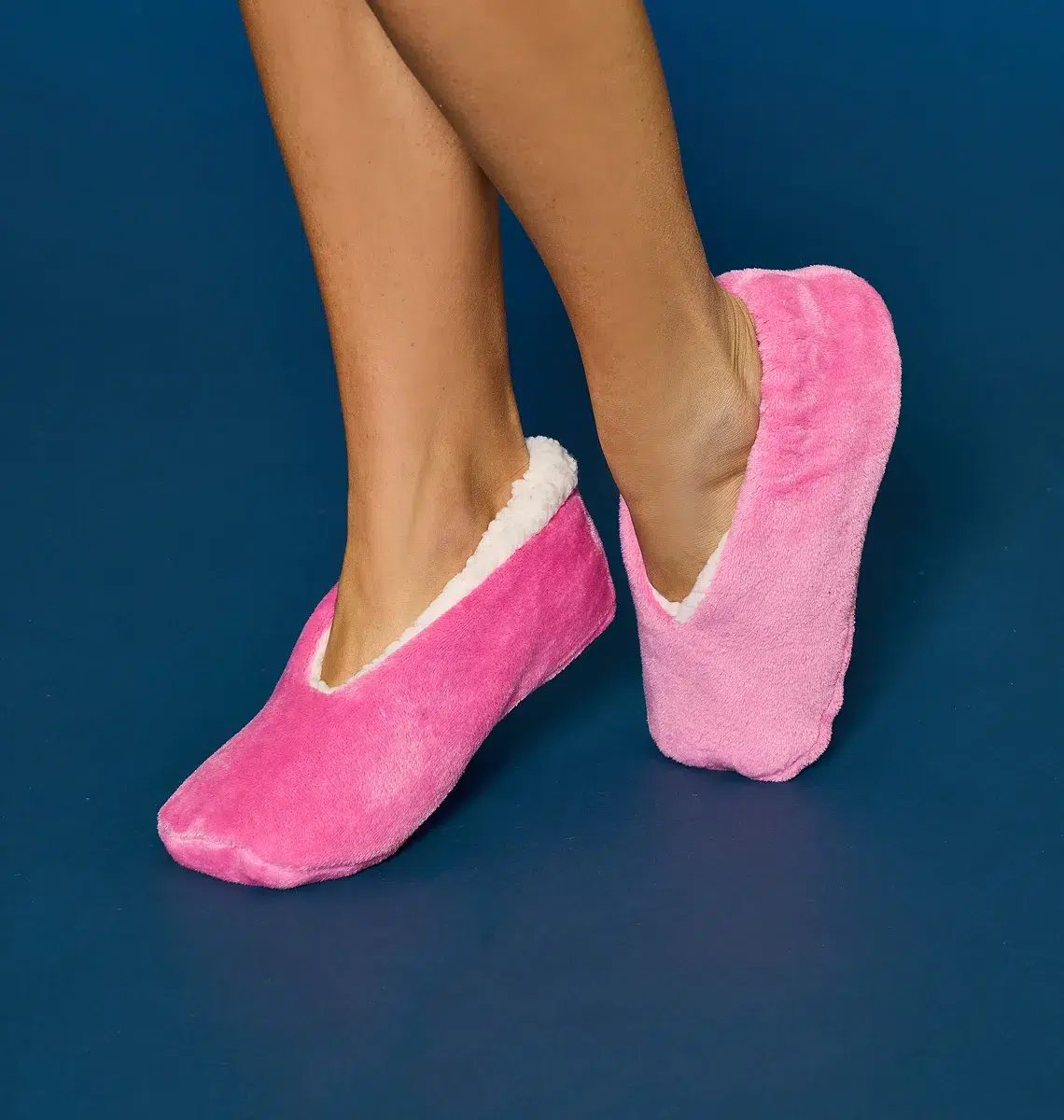 Gambe di una ragazza con pantofole di stoffa rosa