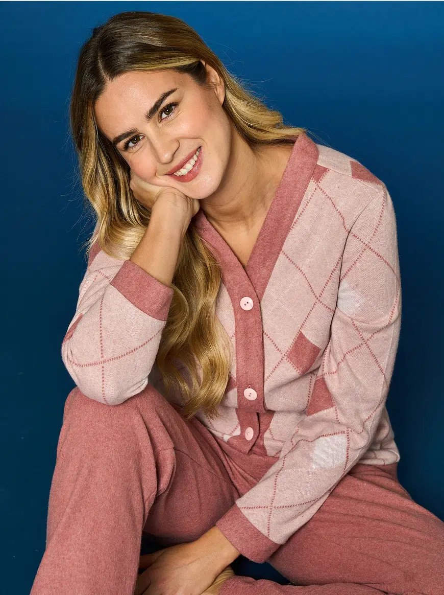 Ragazza bionda con vestito marrone che sorride seduta