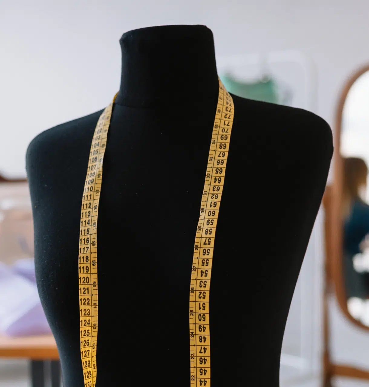 Foto di un manichino nero con una metro da sarta al collo